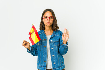 Young spanish woman holding a flag isolated on white background