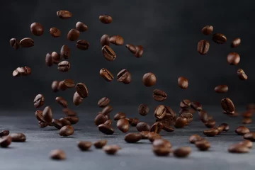  Grains of roasted coffee falling on gray stone background. Levitation coffee beans. Shallow depth of field  © VLADISLAV