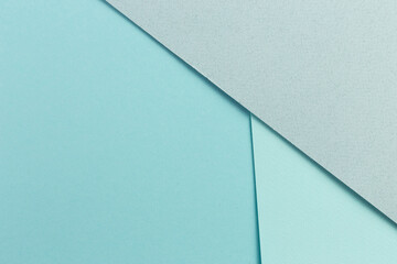 Material design blue background. Craft paper sheets are folded in different ways. A photo.