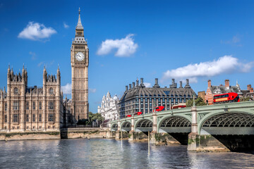 Fototapeta na wymiar Big Ben and Houses of Parliament with red buses on the bridge in London, England, UK