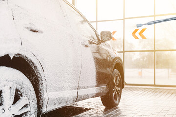 Woman washing his car in a self-service car wash station.Car wash self-service. 