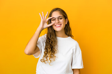 Young caucasian woman excited keeping ok gesture on eye.