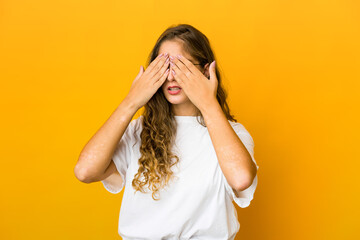 Young caucasian woman afraid covering eyes with hands.