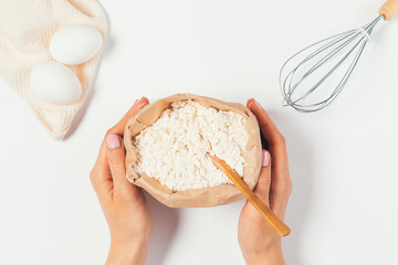 Woman's hands holding paper bag of organic flour