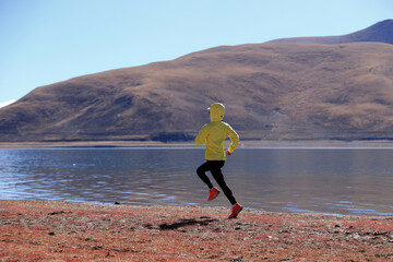 Woman trail runner cross country running  in winter lakeside