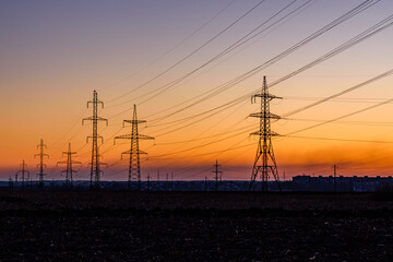 High voltage power line in a field at sunset