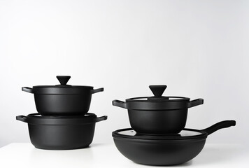 Black cooking pots on grey background front view