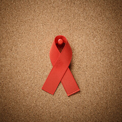 red AID ribbon on cork table flat lay