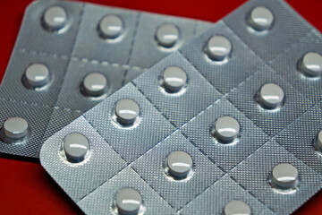 Blister packs of pills on red background 