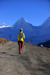 Woman trail runner cross country running  in winter mountains