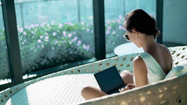 Woman in formal wear surfing internet in business center. Business concept. Businesswoman working on laptop while sitting in lounge zone of modern office or coworking space.