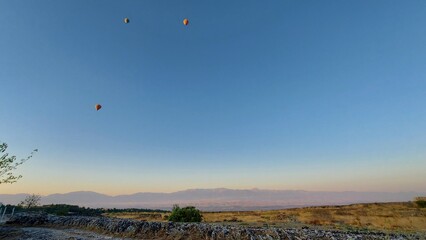 Hot air balloons in the blue sky over the valley at sunrise. High quality photo
