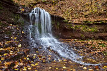Fototapeta na wymiar Beautiful landscape with a waterfall in the autumn forest