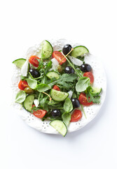 Salad with black Olives, cherry Tomatoes, Cucumber and Rocket on white Background. Close up.	