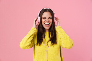 Joyful brunette girl listening music with headphones