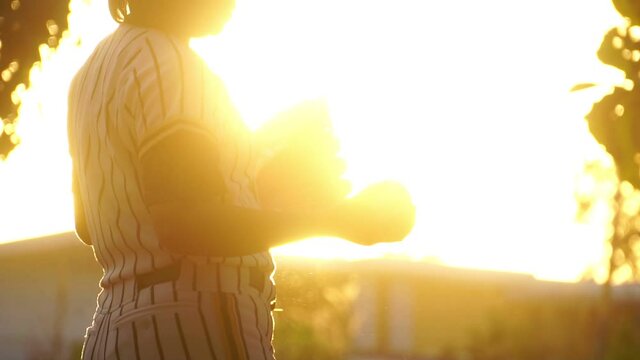 Footage Slow Motion: Close-up female softball player with sunset