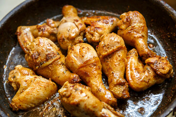 Marinated chicken drumsticks and wings in a pan