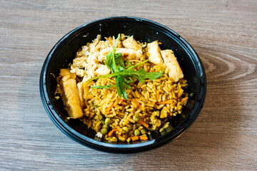 Wok rice cooked with soy sauce, vegetables and chicken pieces.