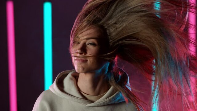 Slow motion of young woman rotating with her hair in neon lights, Filmed on high speed cinema camera.