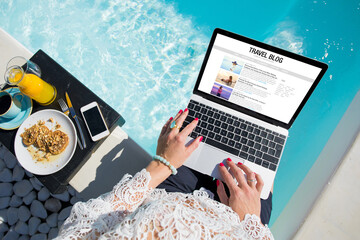 Woman working on her travel blog outdoors by the pool - obrazy, fototapety, plakaty