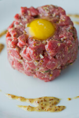 Steak tartare. Classic American restaurant or French bistro appetizer classic. Steak diced, mixed with eggs, red onions, olive oil, lemon juice, garlic and capers. Served with garlic bread.