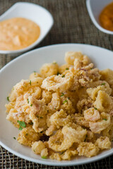 Calamari served with spicy and sweet dipping sauces. Classic American restaurant or French bistro appetizer favorite. Fresh octopus, squid and shrimp battered and deposed fried.