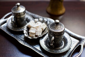 silver plated turkish coffee set and turkish delight. blurry background.