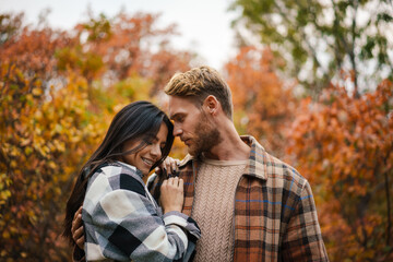 Beautiful happy romantic couple hugging while strolling in forest