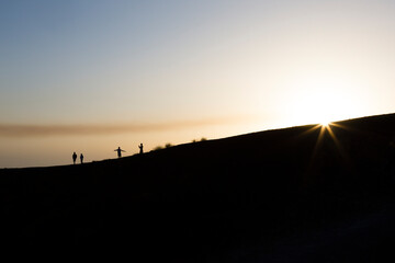 Sicily, Italy. A small group of tourists explore the rim of the Silvestri Inferiore crater near the summit of Mt Etna.