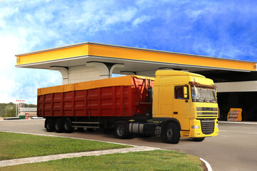 Fototapeta na wymiar Bright truck driving from modern gas filling station