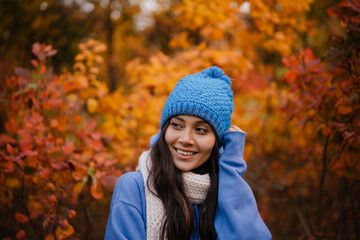 Beautiful happy woman smiling while strolling in autumn forest