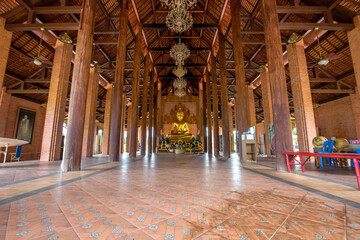 Obraz premium The background of the Wat Pa Kham Charoen is a beautiful old church with a Buddhist statue and a tree-lined temple, with tourists and travelers always making merit in Udon Thani, Thailand.