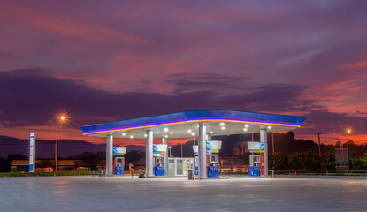 Gas station at sunrise and orange sky .