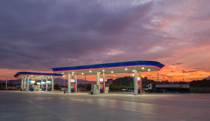 Fototapeta na wymiar Gas station at sunrise and orange sky .