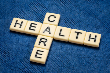 healthcare crossword in ivory letter tiles against textured handmade paper, health care and wellbeing concept