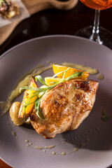 roasted duck breast and orange slices on wooden table at restaurant