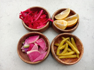 RED CABBAGE, LEMON, YELLOW CHILI PEPPER, RADISH shot together on table.