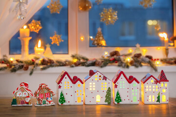 Obraz premium Christmas toy houses on background of decorated window
