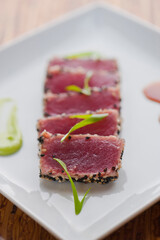 Ahi tuna, pan sesame seared rare. Premium sushi grade tuna seared and served with avocado, cucumber, caviar, ginger, wasabi and soy. Classic fine dining appetizer.