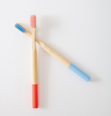 Pink and blue bamboo toothbrushes isolated on white background, top view, copy space