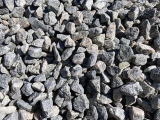 closeup dark stone pepple rocks overhead view with deep shadows and bright details as backdrop background for website architecture presentation scenery