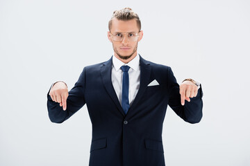  businessman in suit and glasses pointing down isolated on white
