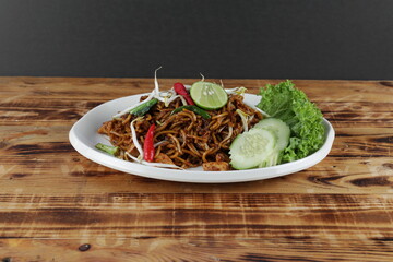 Delicious fried noodles with salad and cucumber