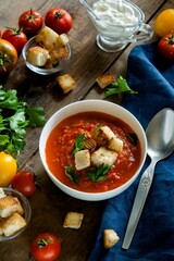 Tomato soup with croutons on a wooden background