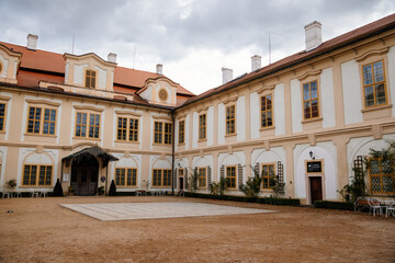 Loucen Rococo castle surrounded by a vast English park, Romantic baroque chateau with Church of the Assumption of the Virgin Mary in autumn day, Central Bohemia, Czech republic