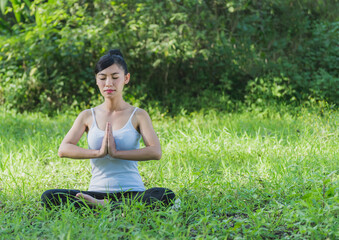 Naklejka na ściany i meble Young women Sitting doing yoga to relax . practice meditation to care wellness outdoor