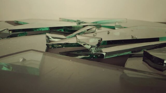 The camera moves over the piled&nbsp;pieces&nbsp;of broken glass.