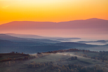 Obraz premium dawn in the mountains fog between the hills.