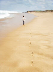 Fototapeta na wymiar Boy Walking On Sand