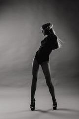 Young beautiful dancer posing in studio on grey background